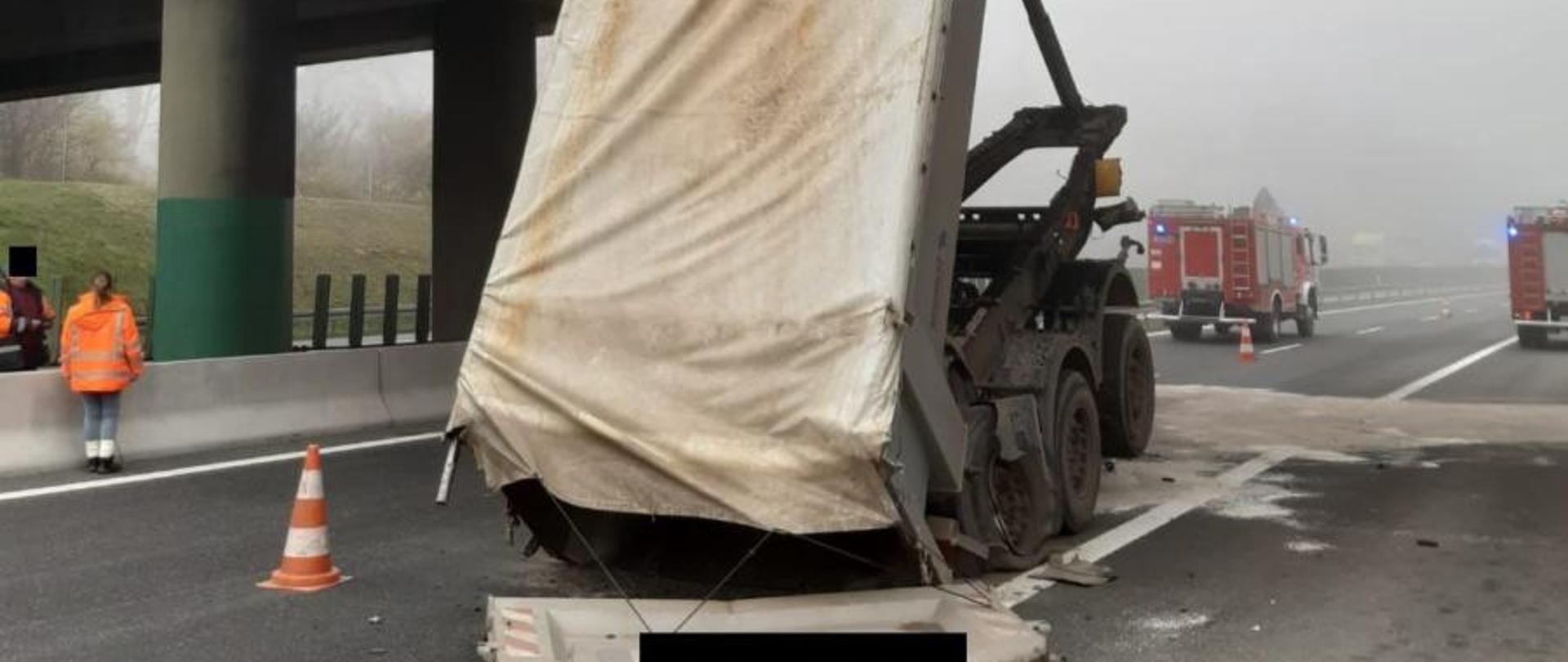 Zdjęcie przedstawia naczepę, która uderzyła we wiadukt oraz wozy strażackie