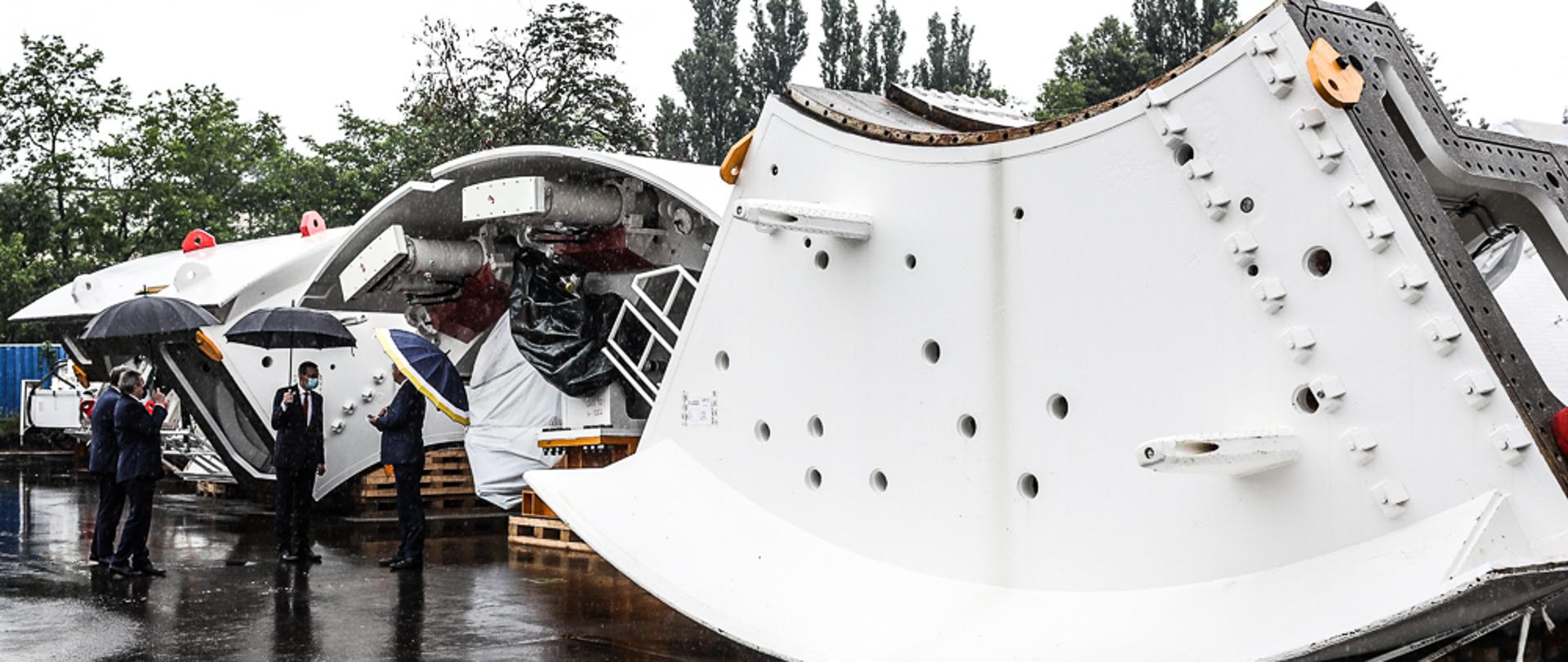 Premier oraz ministrowie stoją przy maszynie.