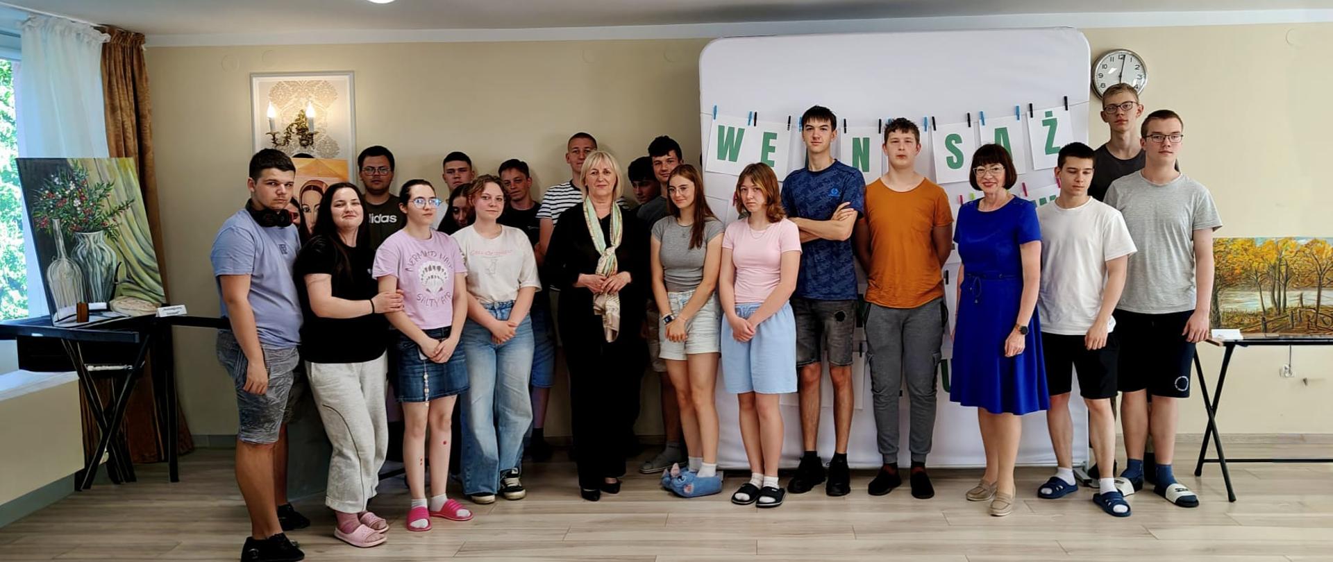 zdjęcie grupy uczniów oraz p. Danuty Mazur podczas otwarcia wernisażu w Mokrzeszowie
