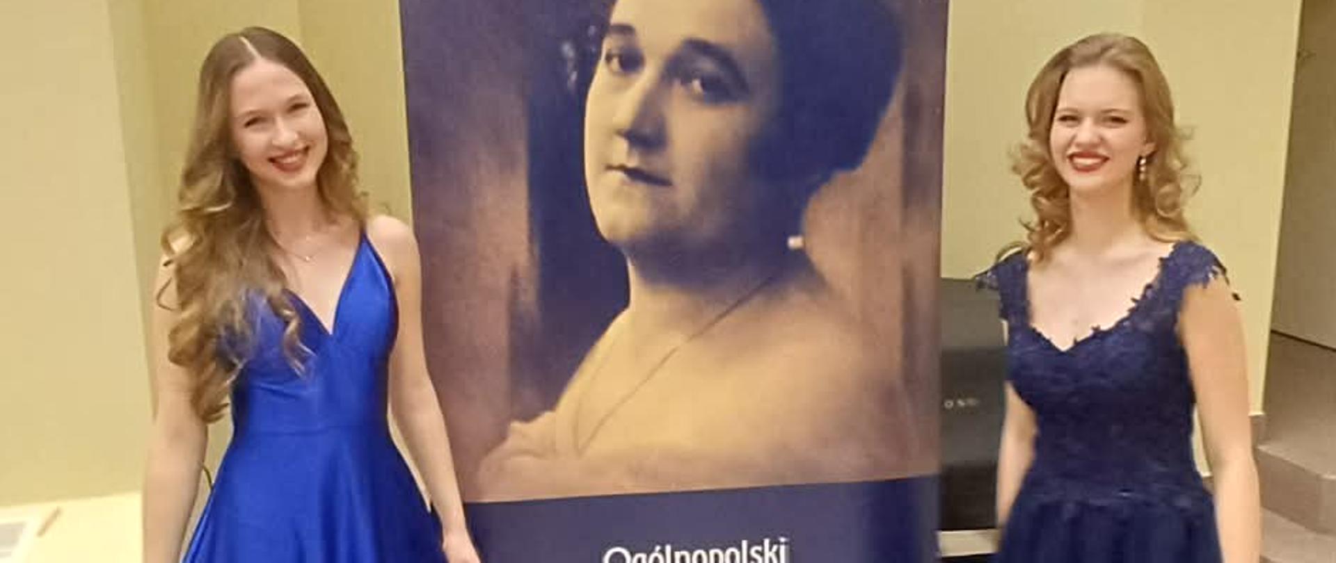 Amelia Szmidt (z lewej) Konkurs Wokalny Wrocław 2026. Obok druga wokalistka. Panie ubrane w niebieskie sukienki, w tle baner konkursu.