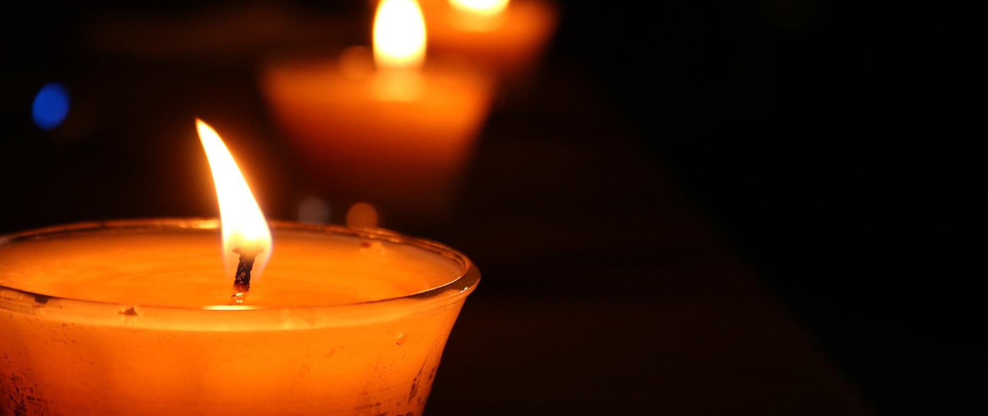 Znicze na czarnym tle