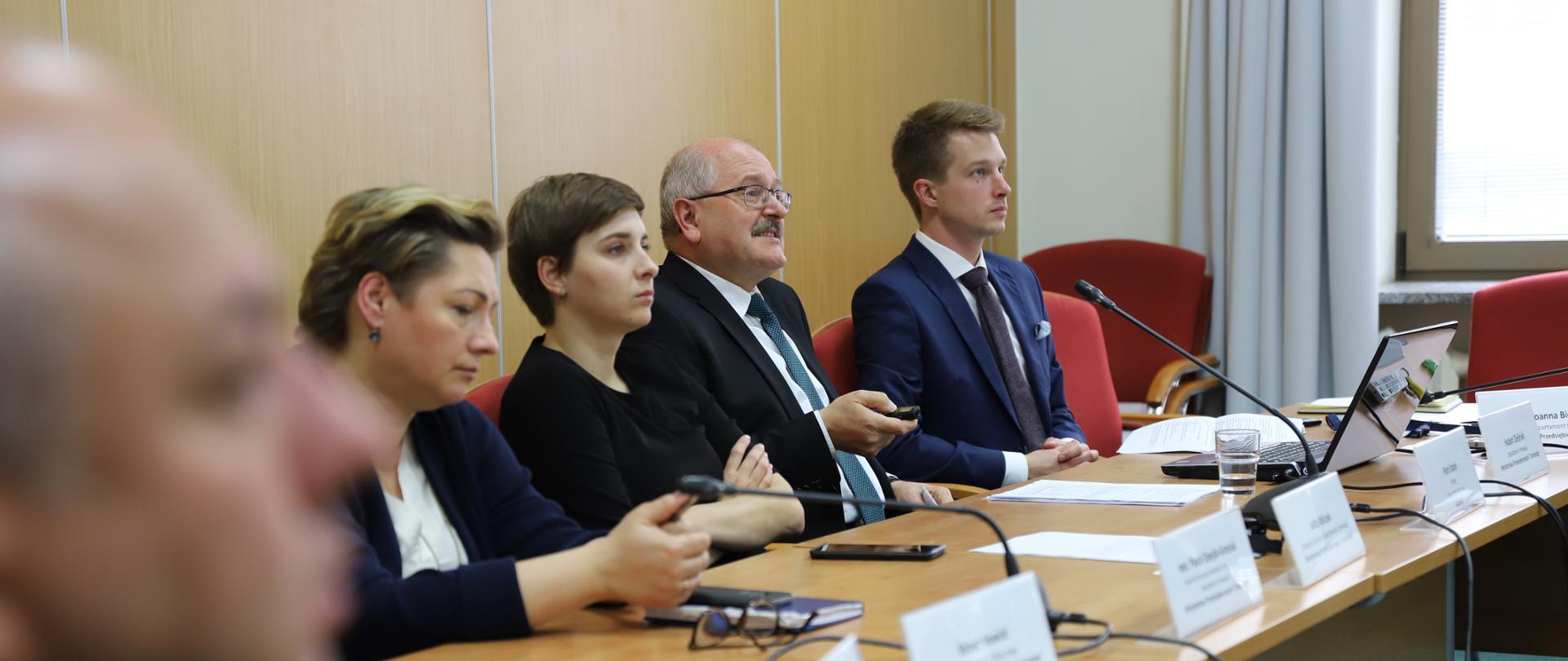 Zdjęcie przedstawia czterech przedstawicieli projektu zasiadający za stołem konferencyjnym.