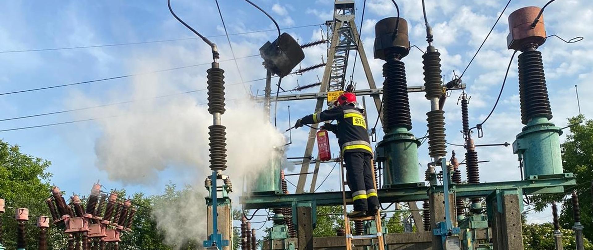 Strażacy prowadza działania gaśnicze palącego się oleju w przekładniku prądowym