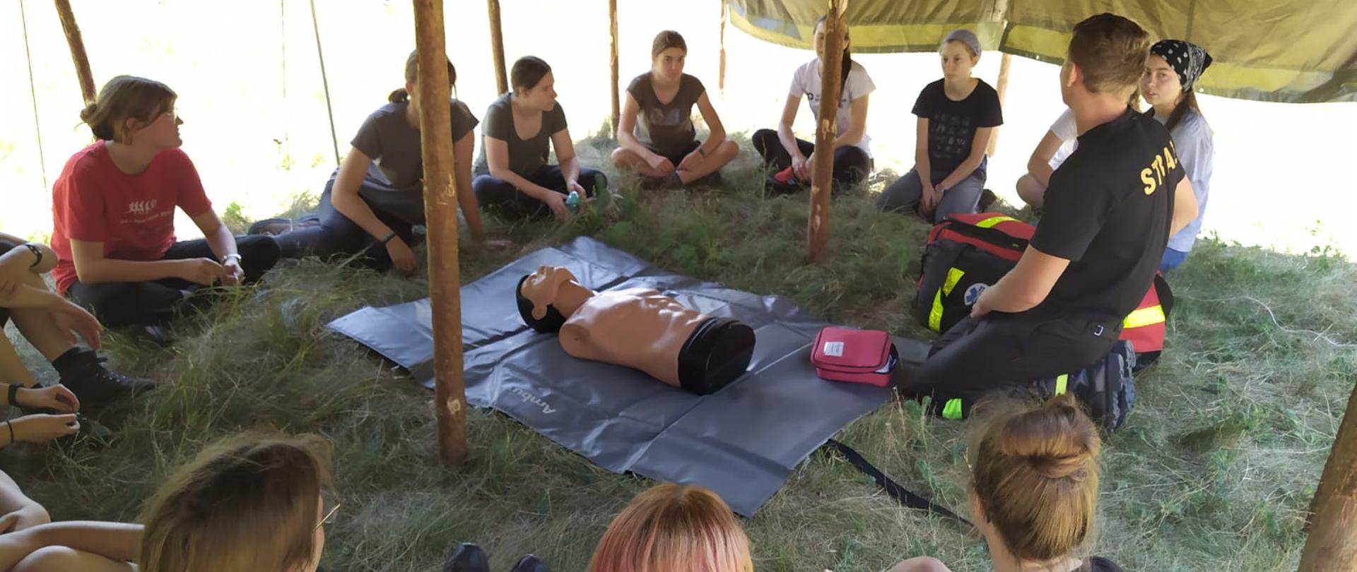 Harcerki uczą się pierwszej pomocy od strażaka