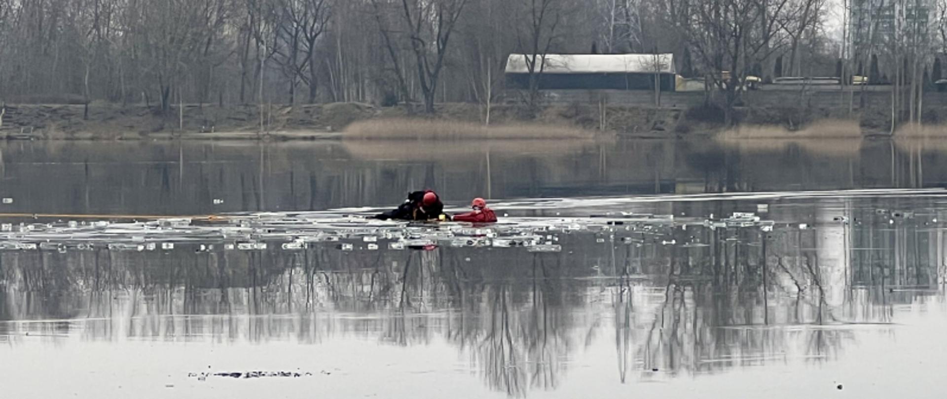 Na zdjęciu widoczny akwen wodny. Na wodzie dwóch strażaków podczas warsztatów ratownictwa lodowego 