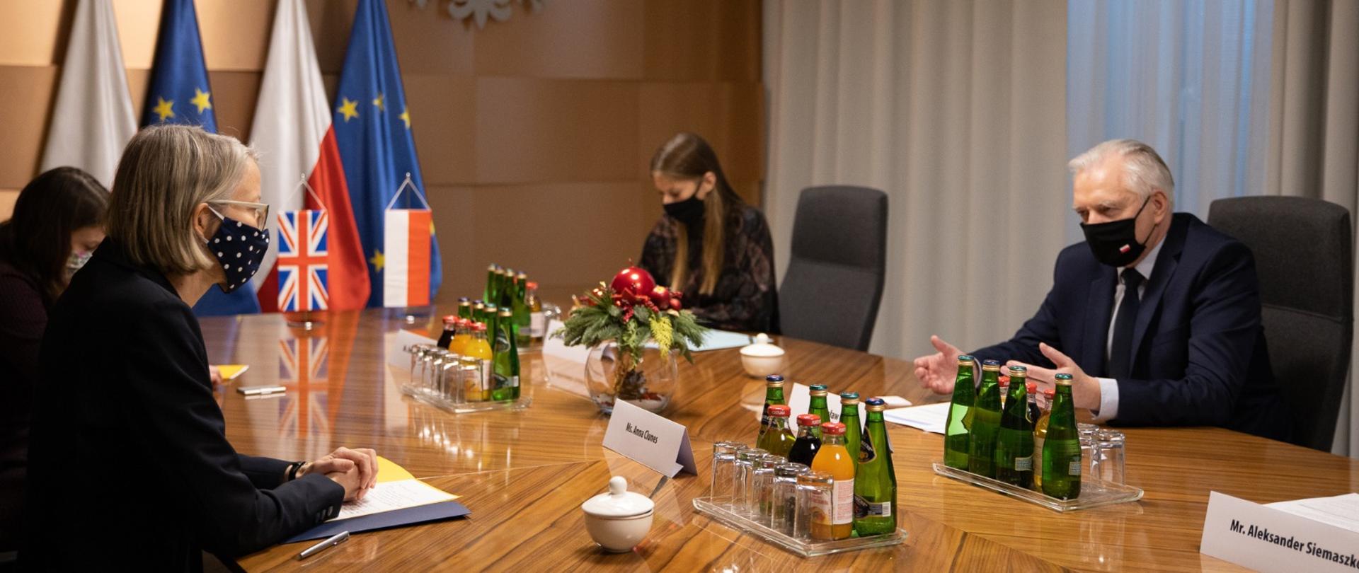 Jarosław Gowin podczas rozmowy z ambasador Wielkiej Brytanii w Polsce Anną Clunes. Siedzą naprzeciwko siebie przy dużym stole konferencyjnym w towarzystwie swoich delegacji.