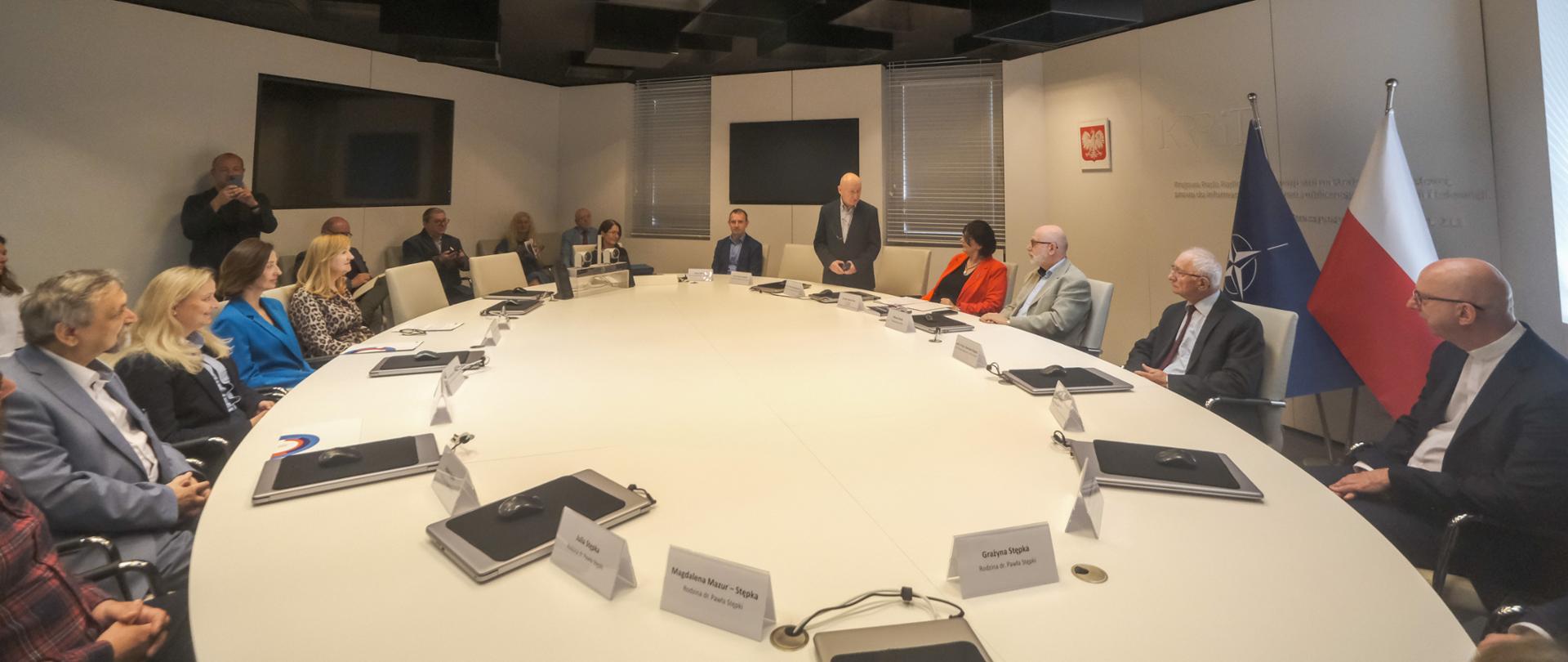 Uroczystość wręczenia nagród im. dr. Pawła Stępki - laureaci siedzą po lewej stronie owalnego stołu, członkowie kapituły siedzą po prawej stronie owalnego stołu