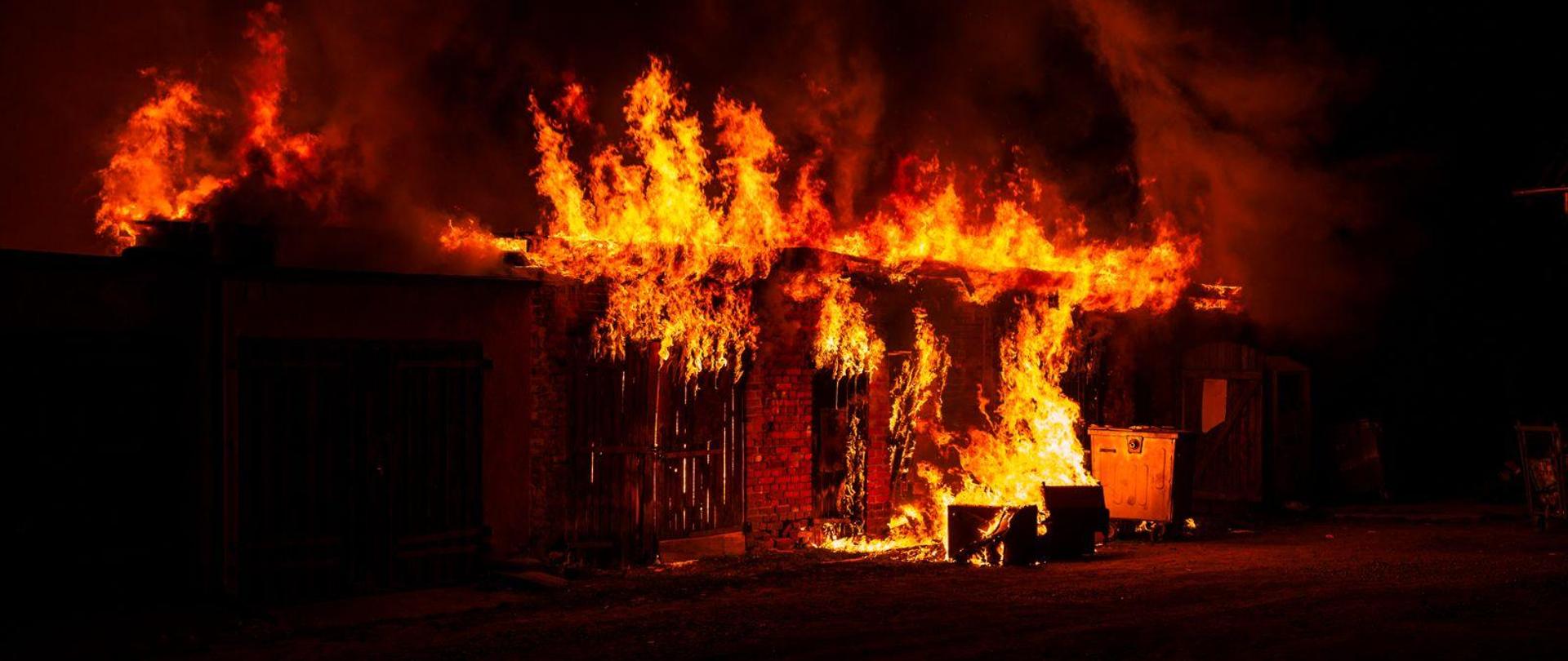 Płomienie wychodzą spod więźby dachowej budynku gospodarczego