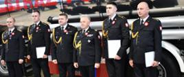 Zdjęcie grupowe odznaczonych na tle cysterny pożarniczej