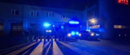 Na zdjęciu widać strażaków Państwowej Straży Pożarnej, którzy oddają hołd tragicznie zmarłemu druhowie OSP. W tle pojazdy pożarnicze oraz jednostka ratowniczo-gaśnicza.