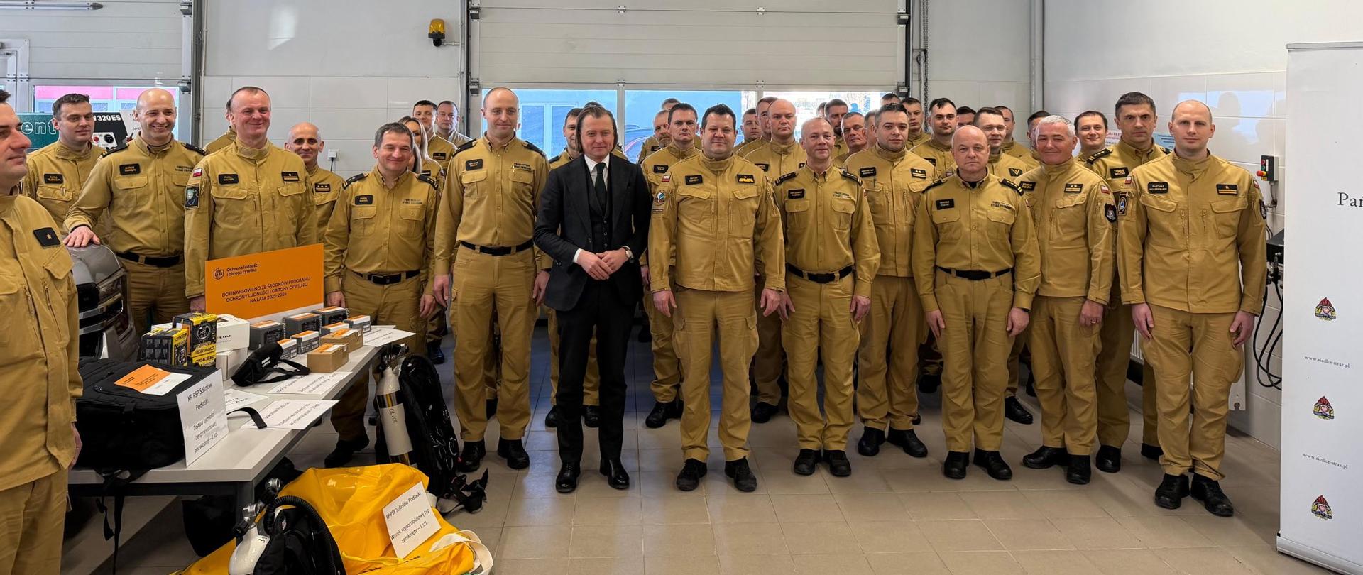 Wspólne zdjęcie osób biorących udział w uroczystym przekazaniu sprzętu i wyposażenia na cele Ochrony Ludności i Obrony Cywilnej
