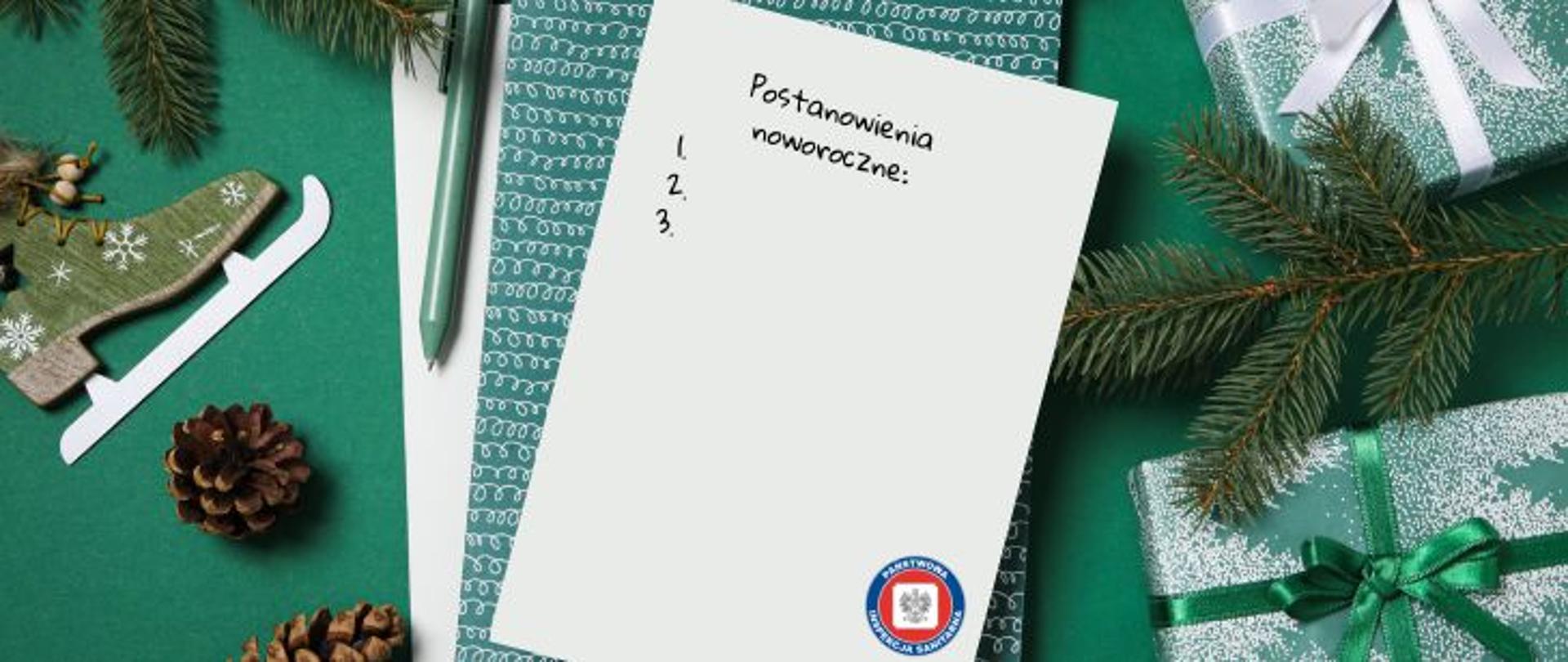 Na zielonym tle wokół notatnika znajdują się zielone gałązki świerku, zapakowane dwa prezenty w ozdobny papier, jeden z zieloną kokardą, a drugi z białą kokardą. Obok po lewej położne szyszki, obok zielony długopis. Na środku jasna kartka zatytułowana Postanowienia noworoczne. W prawym dolnym rogu kartki logo Państwowej Inspekcji Sanitarnej.