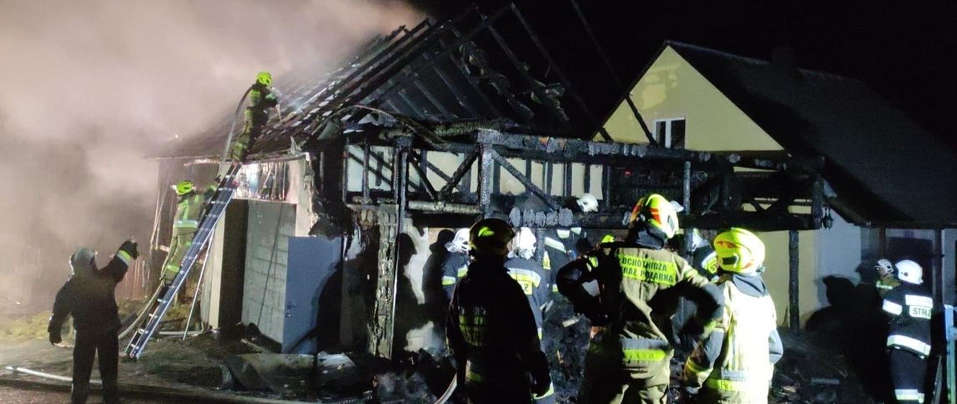 Zdjęcie zrobione podczas pożaru w miejscowości Jabłonka. Na zdjęciu spalany budynek gospodarczy, strażacy prowadzący działania gaśnicze.