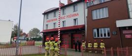 zbiórka 10 strażaków przed budynkiem KP PSP we Włoszczowie przygotowujących się do podniesienia flagi