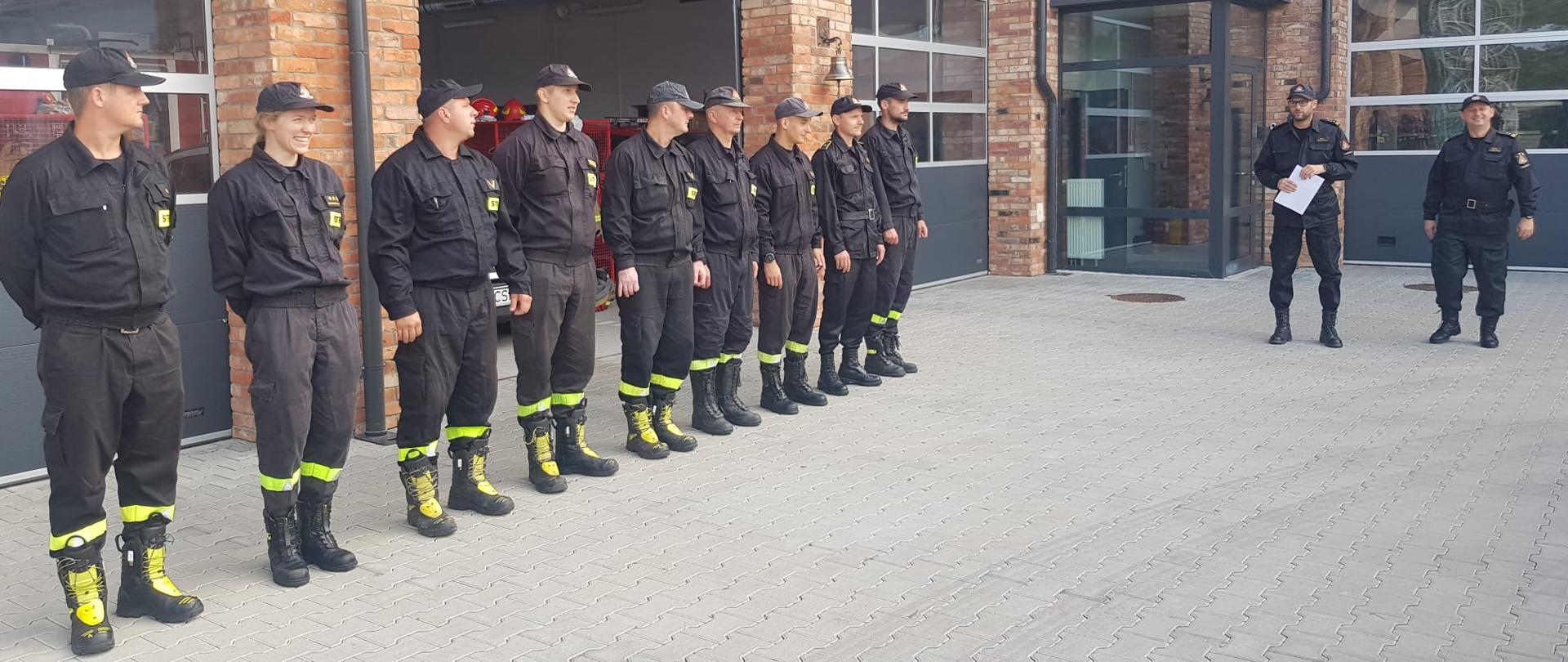 Na placu Komendy Powiatowej Państwowej Straży Pożarnej od prawej stoi Dowódca Jednostki Ratowniczo-Gaśniczej brygadier Paweł Puchowski, Komendant Powiatowy Państwowej Straży Pożarnej w Świeciu straszy brygadier Piotr Tkaczyński. Po lewej w szeregu stoją funkcjonariusze Komendy Powiatowej Państwowej Straży Pożarnej w Świeciu.