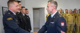 Na zdjeciu widoczny jest Komendant Powiatowy PSP w Ostrowcu Świętokrzsykim Marcin Jasiński wręczający mianowanie na wyższe stanowisko funkcjonariuszowi