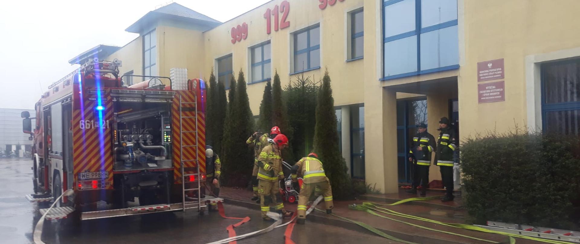 Samochody strażackie przed budynkiem PSP