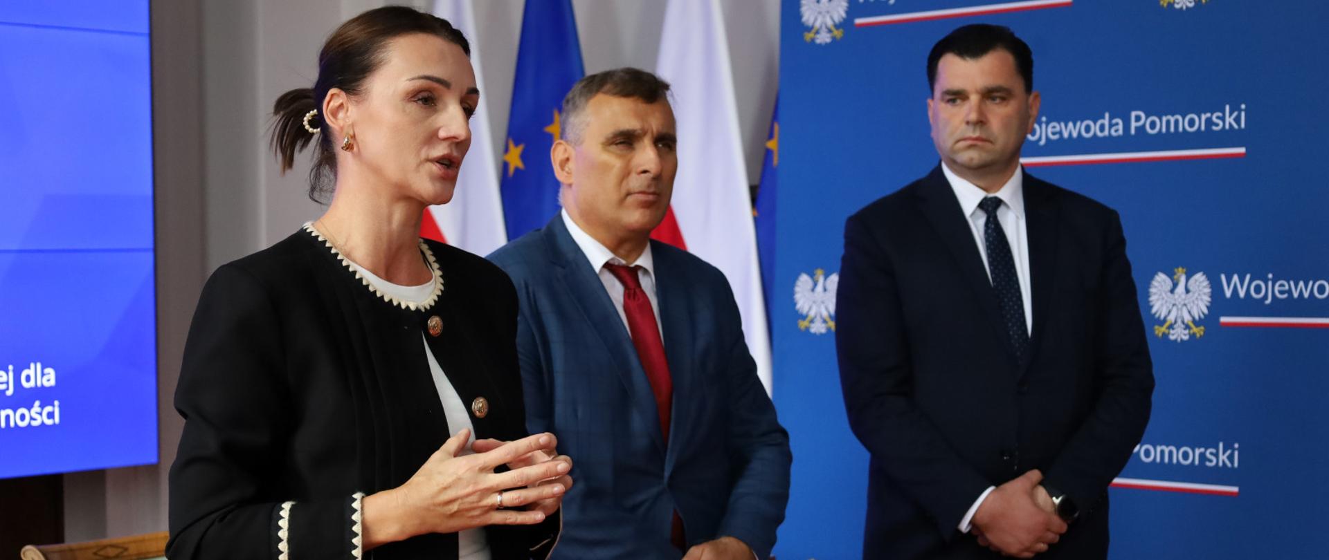 trzy osoby, w tym wojewoda pomorska, zabierają głos przed podpisaniem umowy o dofinansowaniu budowy domu dla niepełnosprawnych