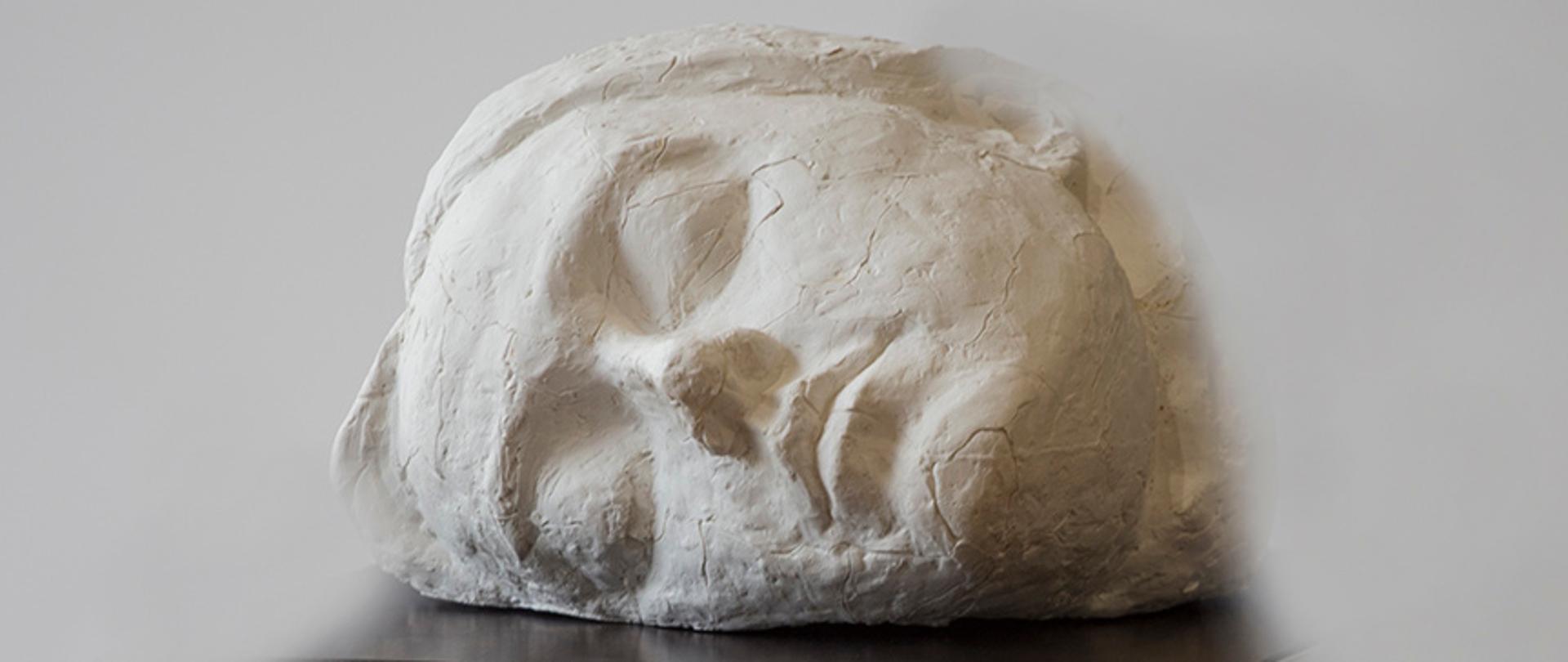 Rzeźba głowy młodej kobiety w pozycji horyzontalnej