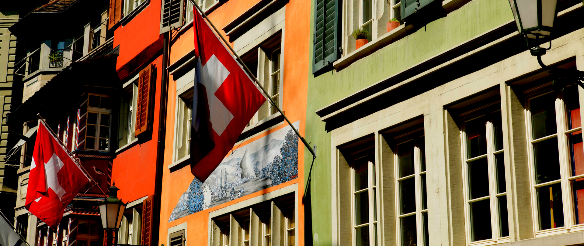 Fasady budynków z widocznymi flagami Szwajcarii