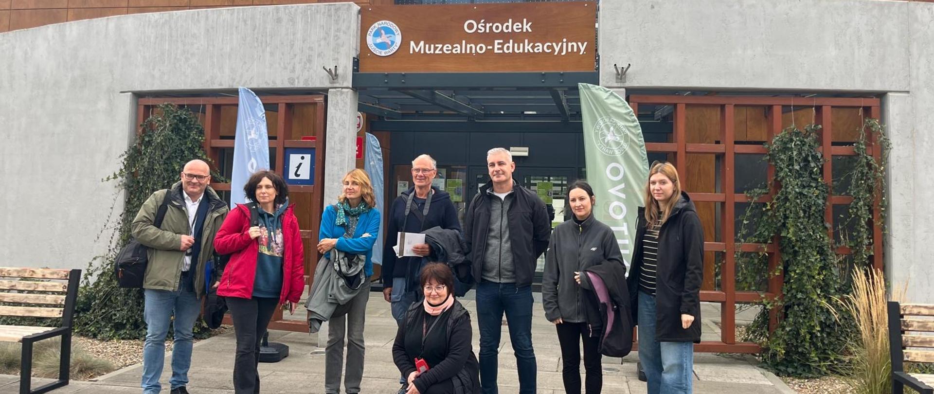 Grupa kilku osób stoi przed budynkiem Ośrodka Muzealno-Edukacyjnego w Słońsku