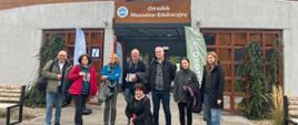 Grupa kilku osób stoi przed budynkiem Ośrodka Muzealno-Edukacyjnego w Słońsku
