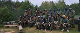 Grupa osób z strojach do paintballa