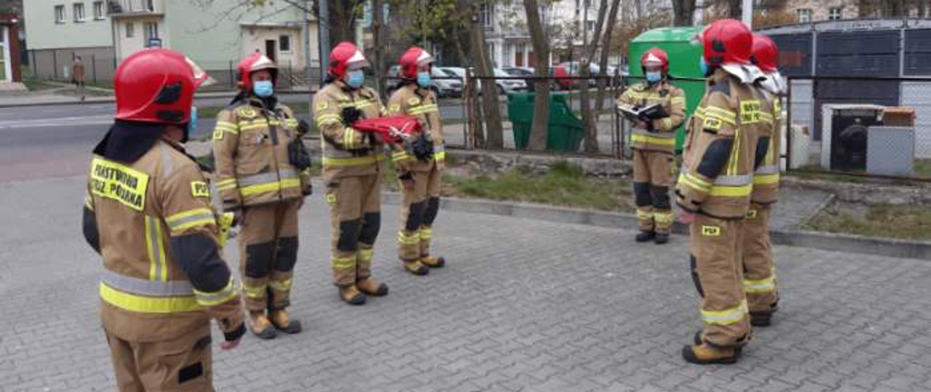 Zdjęcie przedstawia strażaków podczas apelu porannego z okazji dnia flagi.