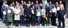 Pamiątkowe zdjęcie grupowe uczestników szkolenia aktualizującego dla inspektorów ochrony przeciwpożarowej (23 osoby) w towarzystwie Zastępcy Komendanta Centralnej Szkoły PSP, oficera CS PSP oraz kobiety