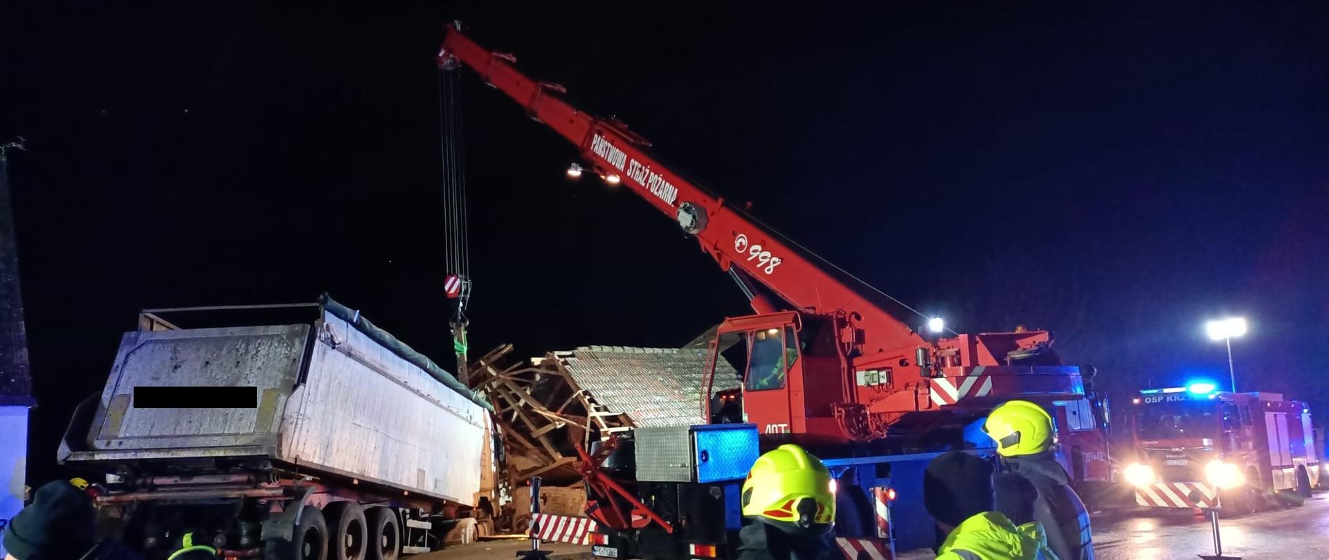 Dźwig wyciągający ciężarówkę z budynku