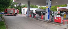Stacja benzynowa zabezpieczana przez pojazdy straży pożarnej, patrolu saperskiego i policji