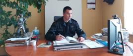 Na zdjęciu widać Komendanta Powiatowego PSP w Oleśnicy przed monitorem komputera.