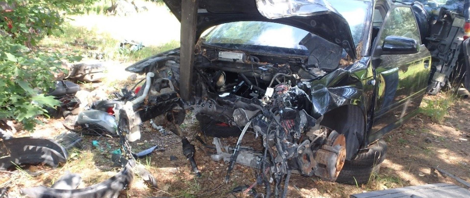 Pojazd po demontażu, porozrzucane elementy na glebie.