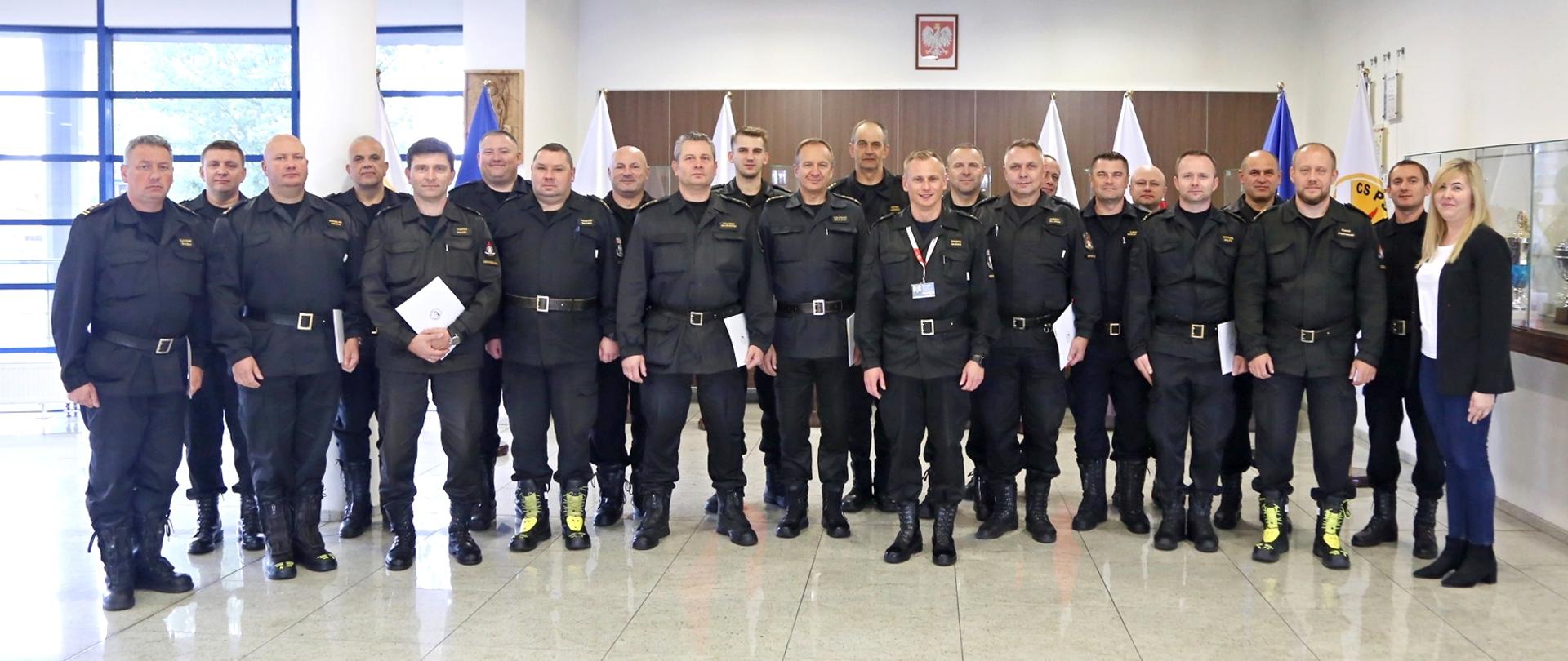 Grupowe zdjęciu uczestników szkolenia (19 osób) w towarzystwie Zastępcy Komendanta Centralnej Szkoły PSP oraz trójki pracowników CS PSP