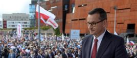 Premier na tle tłumu i flag Polski i Solidarności.