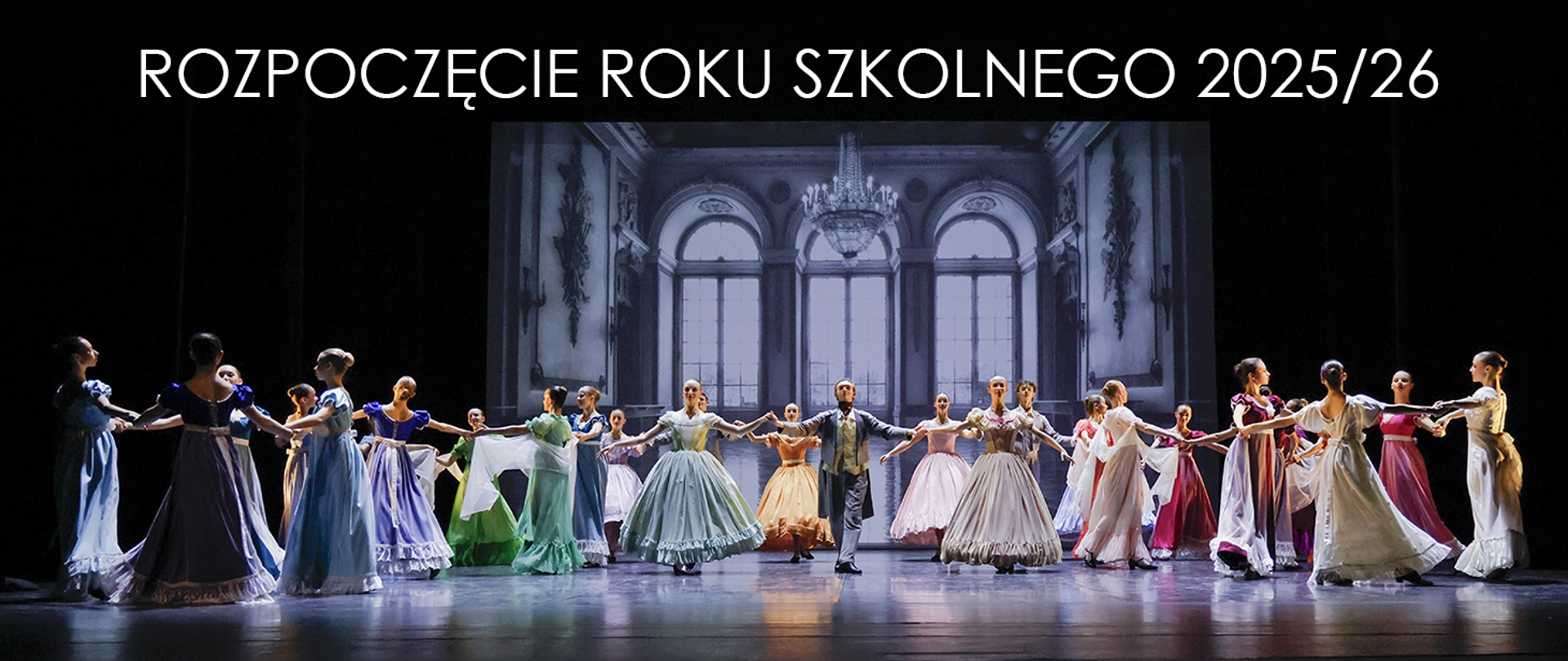 scena z ciemnym tłem, w oddali inscenizacja okien, na głównej scenie oświetlonej, tancerze i tancerki w kolorowych strojach