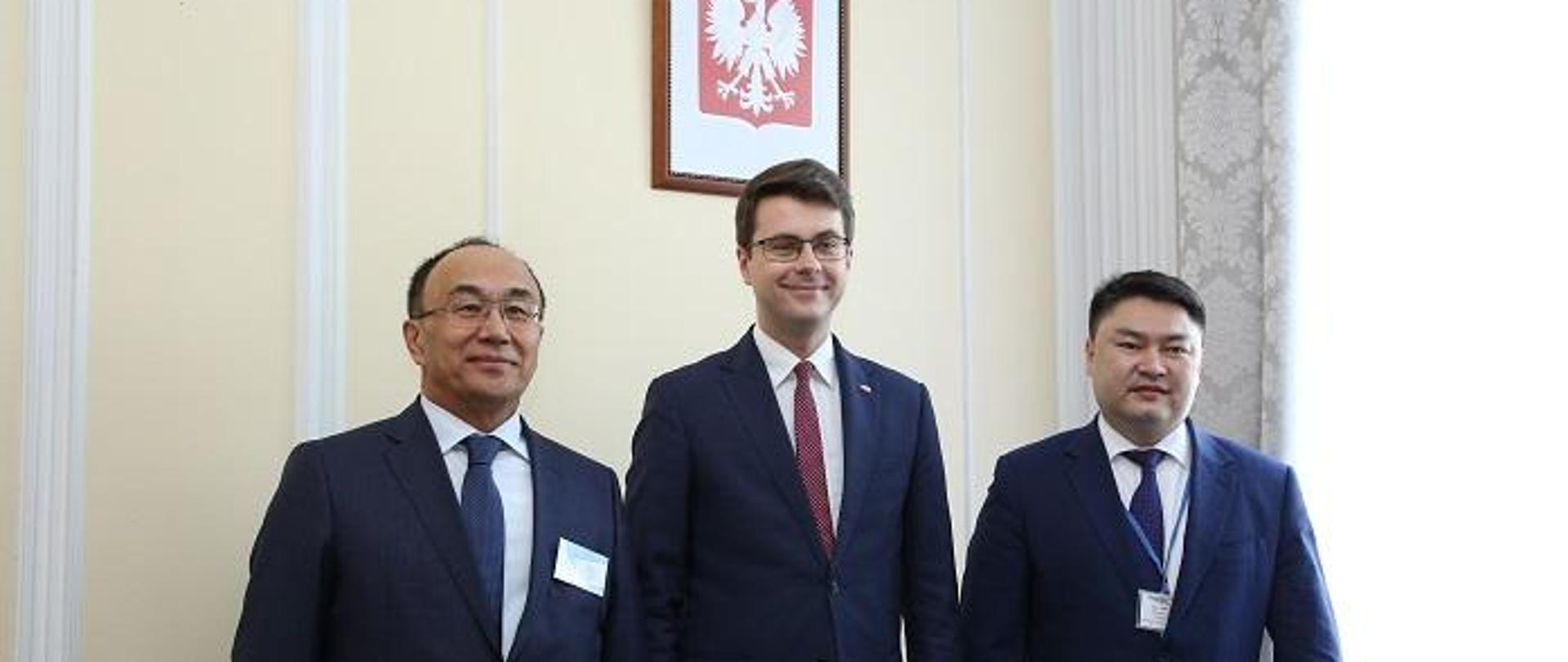 Piotr Müller i przedstawiciele Kazachstanu stoją na tle ściany z godłem RP