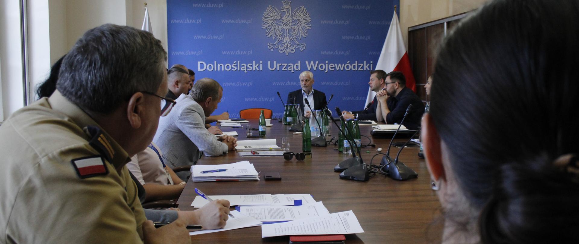 Osoby siedzące przy stole.