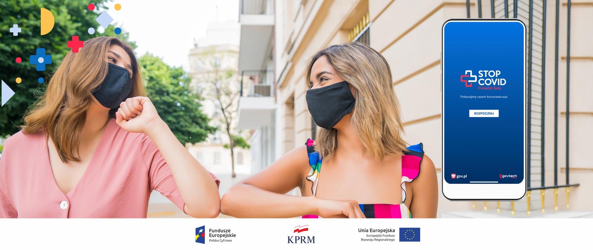 Dwie młode uśmiechnięte kobiety w czarnych maseczkach, witają się przez dotknięci łokciem. z prawej strony ekran smartfona, na którym widoczny jest ekran startowy aplikacji STOP COVID.
