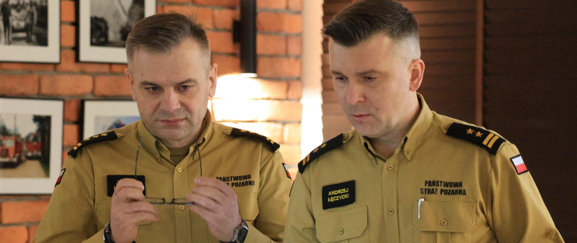 Narada roczna w Komendzie Powiatowej PSP w Mońkach - komendanci - wojewódzki i powiatowy patrzą w ekran laptopa