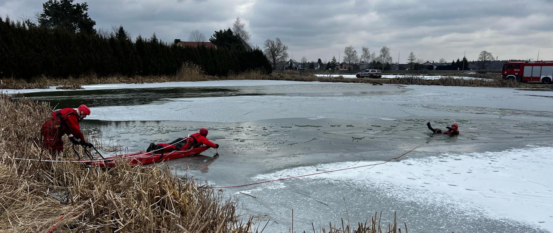 Zdjęcie prezentuje strażaków ćwiczących podejmowanie osoby z załamanego lodu