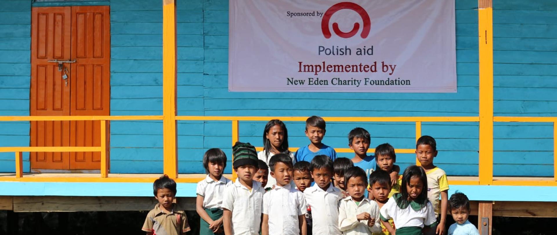 grupa dzieci przed budynkiem szkoły 