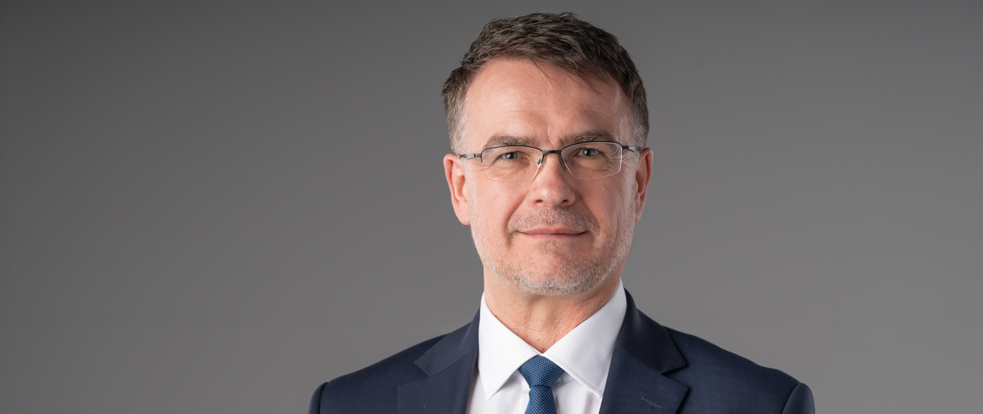 Adam Musiuk, Podlaski Wojewódzki Konserwator Zabytków. Mężczyzna ubrany jest w garnitur, białą koszulę i niebieski krawat.