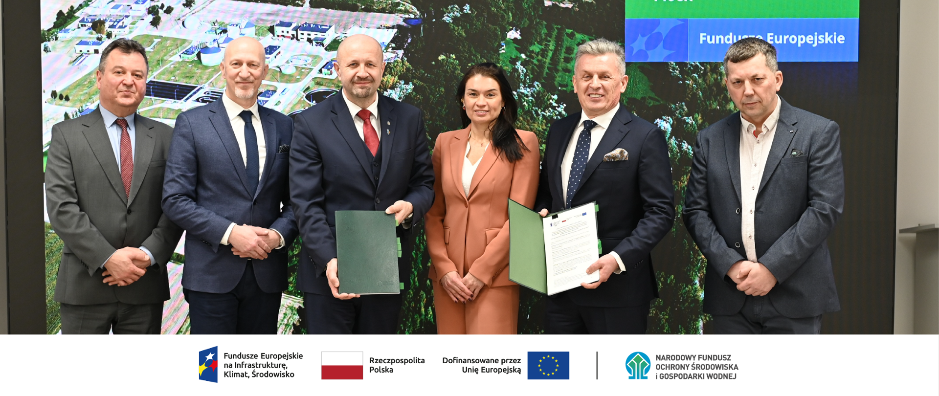 Na zdjęciu od lewej strony: Robert Markiewicz, dyrektor Departamentu Adaptacji do Zmian Klimatu NFOŚiGW, Krzysztof Buczkowski, wiceprezes zarządu Wodociągi Płockie Sp. z o.o., Robert Gajda, zastępca prezesa zarządu NFOŚiGW, Agata Buczek, kierownik JRP Wodociągi Płockie Sp. z o.o., Andrzej Wiśniewski, prezes zarządu Wodociągi Płockie Sp. z o.o., Jan Wolańczyk, NFOŚiGW. W stopce zdjęcia ciąg logotypów: Fundusze Europejskie na Infrastrukturę, Klimat, Środowisko, flaga Rzeczypospolita Polska, flaga UE i Dofinansowane przez UE, NFOŚiGW.