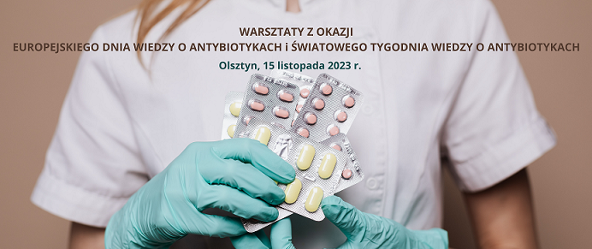 Na zdjęciu widoczny tors kobiety w białym fartuchu, która trzyma w dłoniach w rękawiczkach jednorazowych kilka opakowań antybiotyków. 