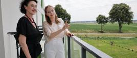 Minister funduszy i polityki regionalnej Katarzyna Pełczyńska-Nałęcz stoi na balkonie budynku mieszkalnego w Kaczorach, wybudowanego w ramach SIM przez KZN Wielkopolska, po jej prawej stronie stoi kobieta