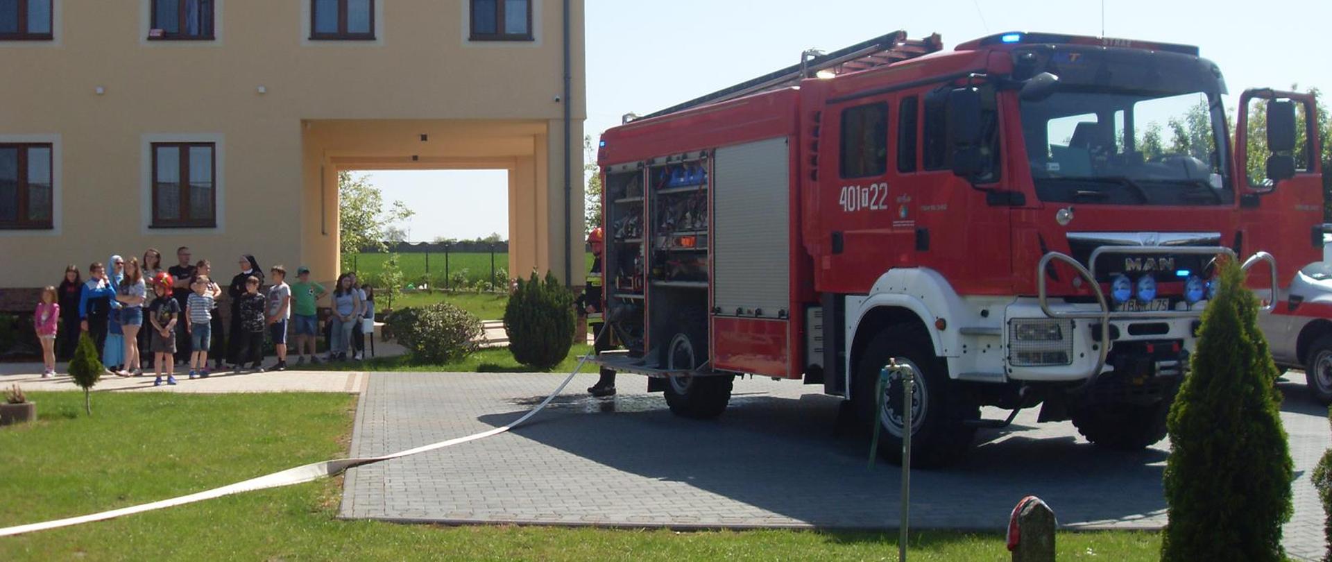 Pokaz sprzętu ratowniczego dla podopiecznych placówki na placu zewnętrznym 