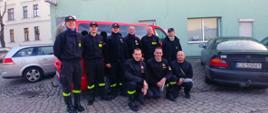 Grupowe zdjęcie strażaków na tle samochodu pożarniczego