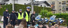 Policjant prowadzi instruktaż dla dzieci jak bezpiecznie jeździć na rowerze