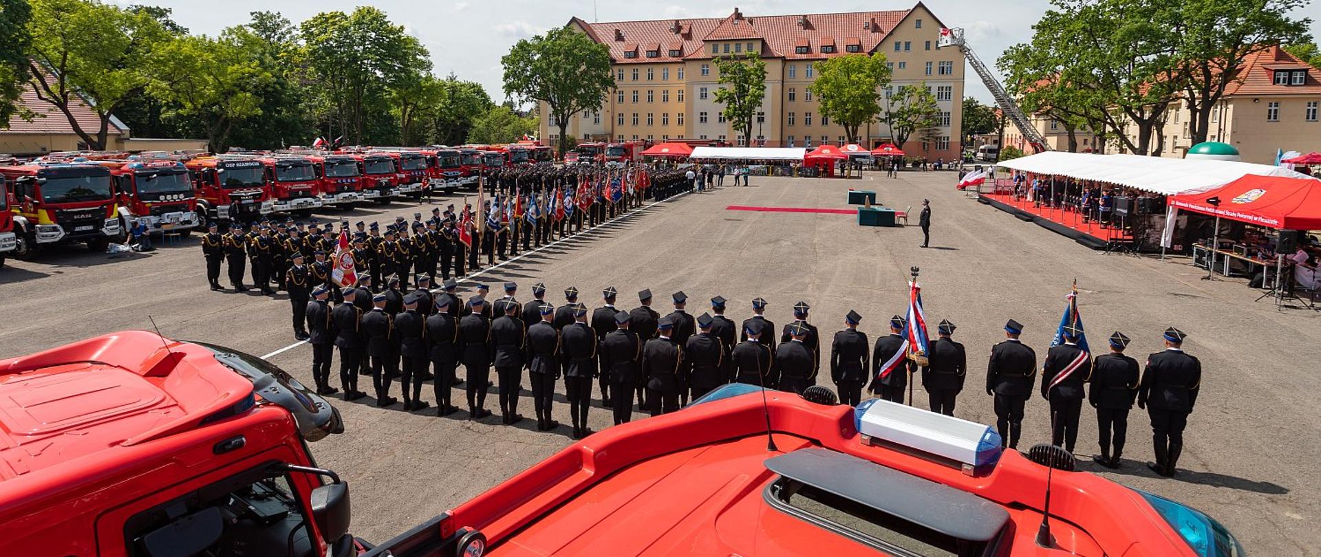 Na zdjęciu widać plac defiladowy, na którym znajduję się wszystkie pododdziału biorące udział w uroczystości oraz samochody pożarnicze.